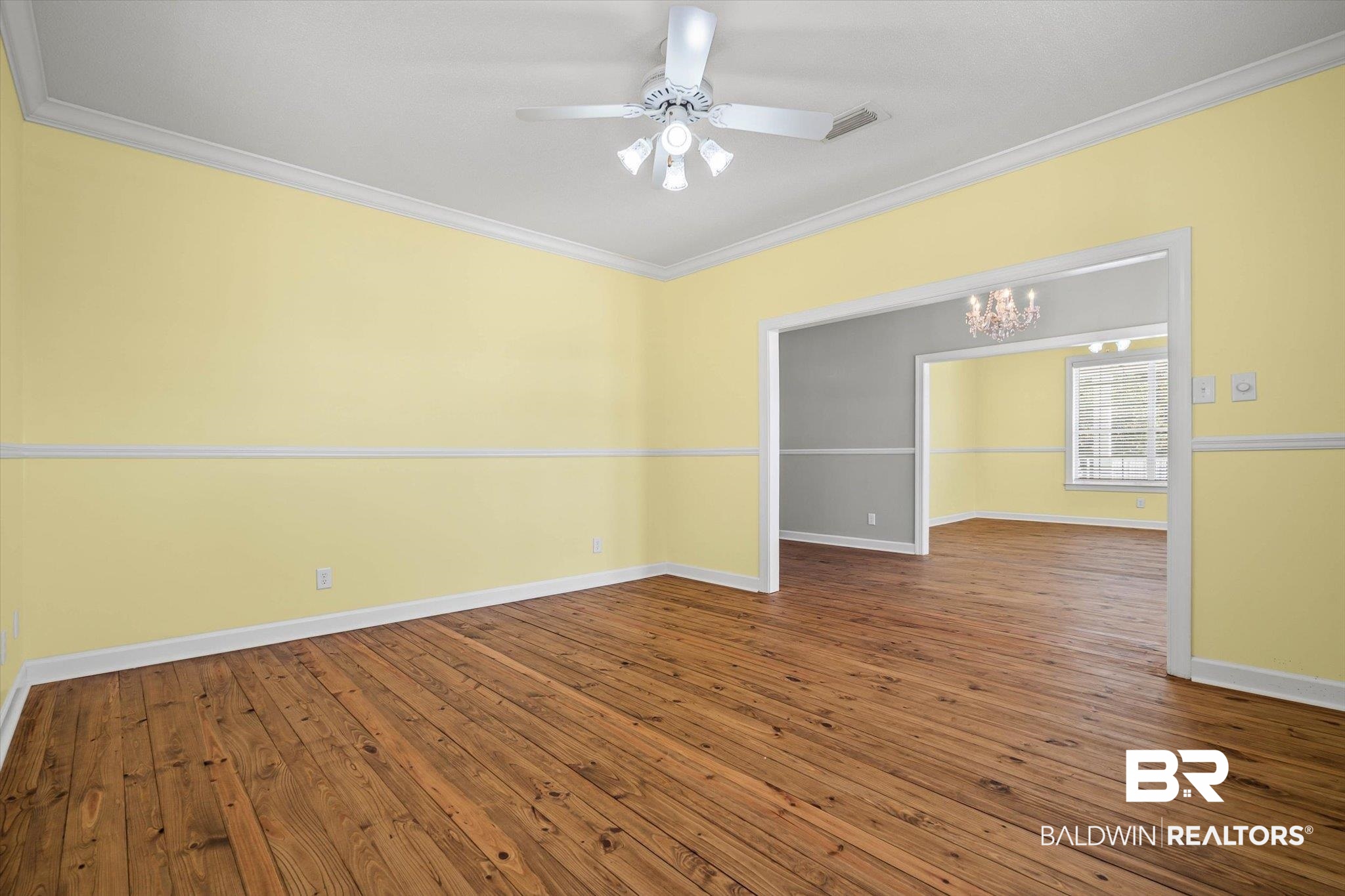 7650 Iron Rush Road Wilmer, AL 36587 - Photo 16 of 34 Unfurnished room with ornamental molding, a chandelier, dark wood-style floors, and a ceiling fan