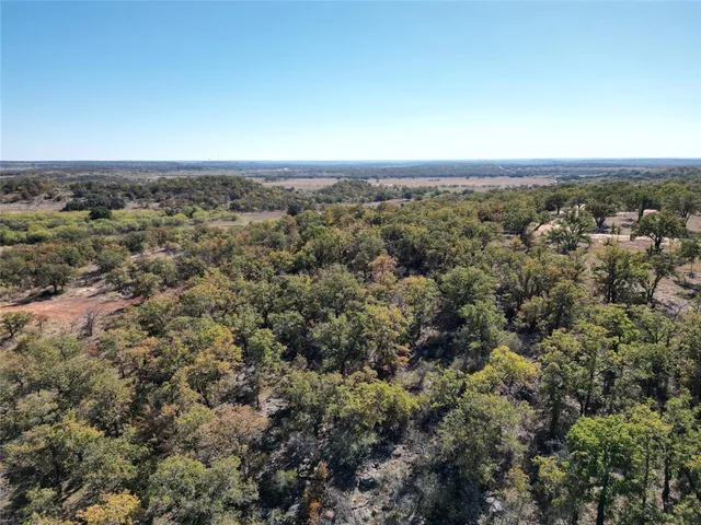 an aerial view of house with yard and mountain view in back