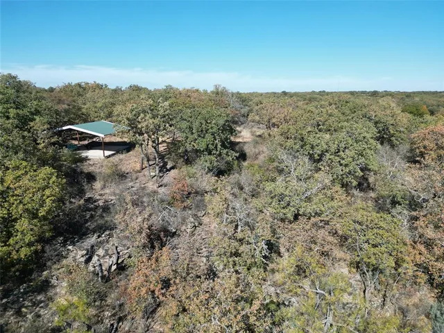 an aerial view of house with yard and mountain view in back