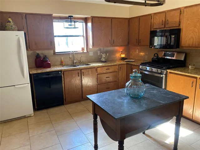 a kitchen with a refrigerator a stove a microwave and cabinets