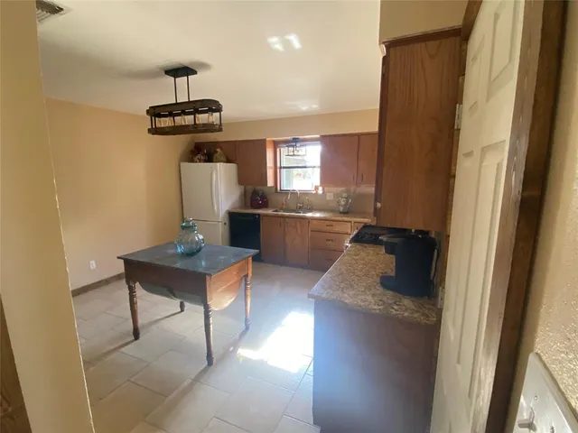 a kitchen with stainless steel appliances granite countertop a sink a stove and a refrigerator