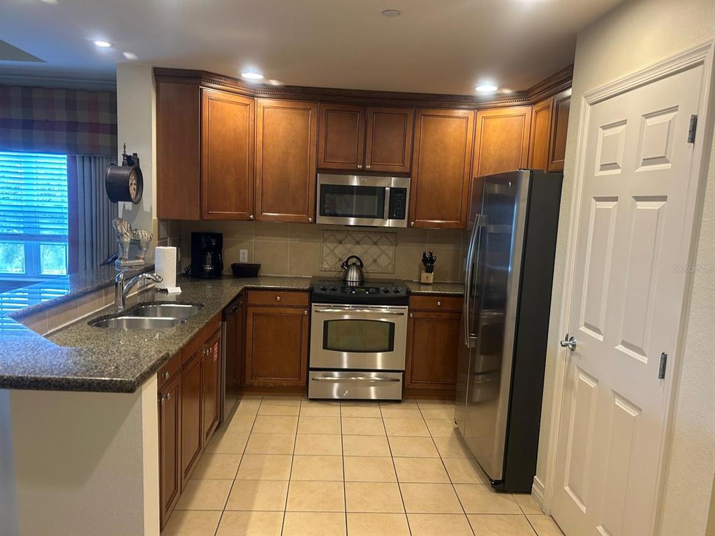 Undisclosed Address Reunion, FL 34747 - Photo 8 of 29 a kitchen with a refrigerator sink and cabinets