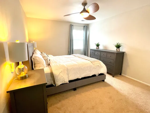 a bedroom with a bed dresser and a window