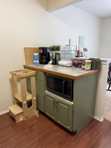 a kitchen with a sink and wooden floor
