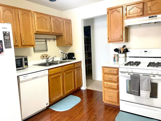 a kitchen with granite countertop wooden cabinets and white appliances