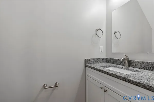 a bathroom with a granite countertop sink and mirror