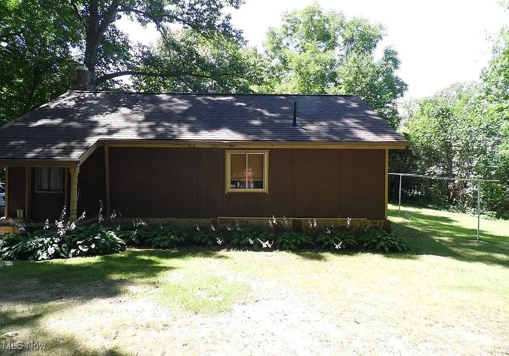 890 Mill Road Ravenna, OH 44266 - Photo 4 of 18 View of side of home featuring a lawn and a shingled roof