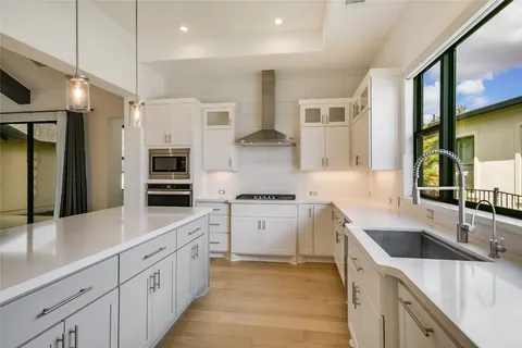 a kitchen with stainless steel appliances granite countertop a sink a stove and a refrigerator