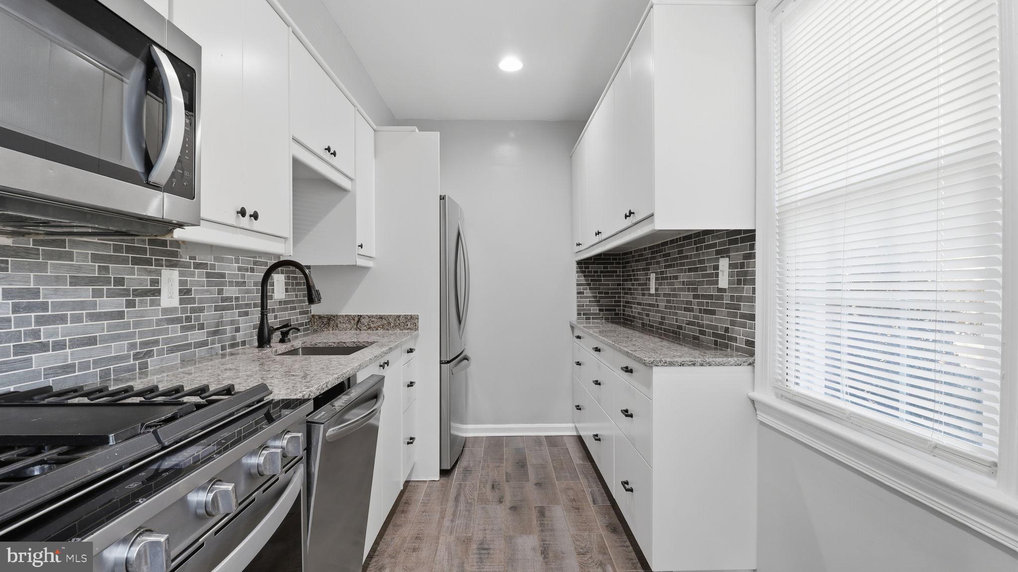 5100 Columbia Pike, Unit 1 Arlington, VA 22204 - Photo 11 of 40 a kitchen with stainless steel appliances a stove a sink and a microwave