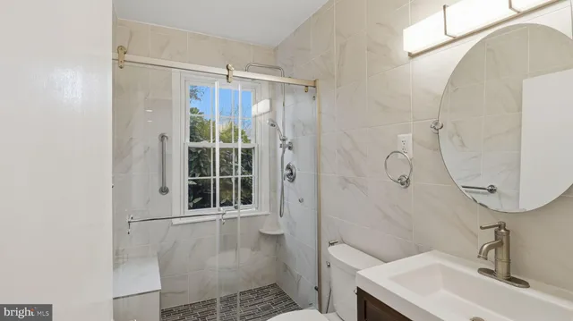 a bathroom with a sink a toilet and shower