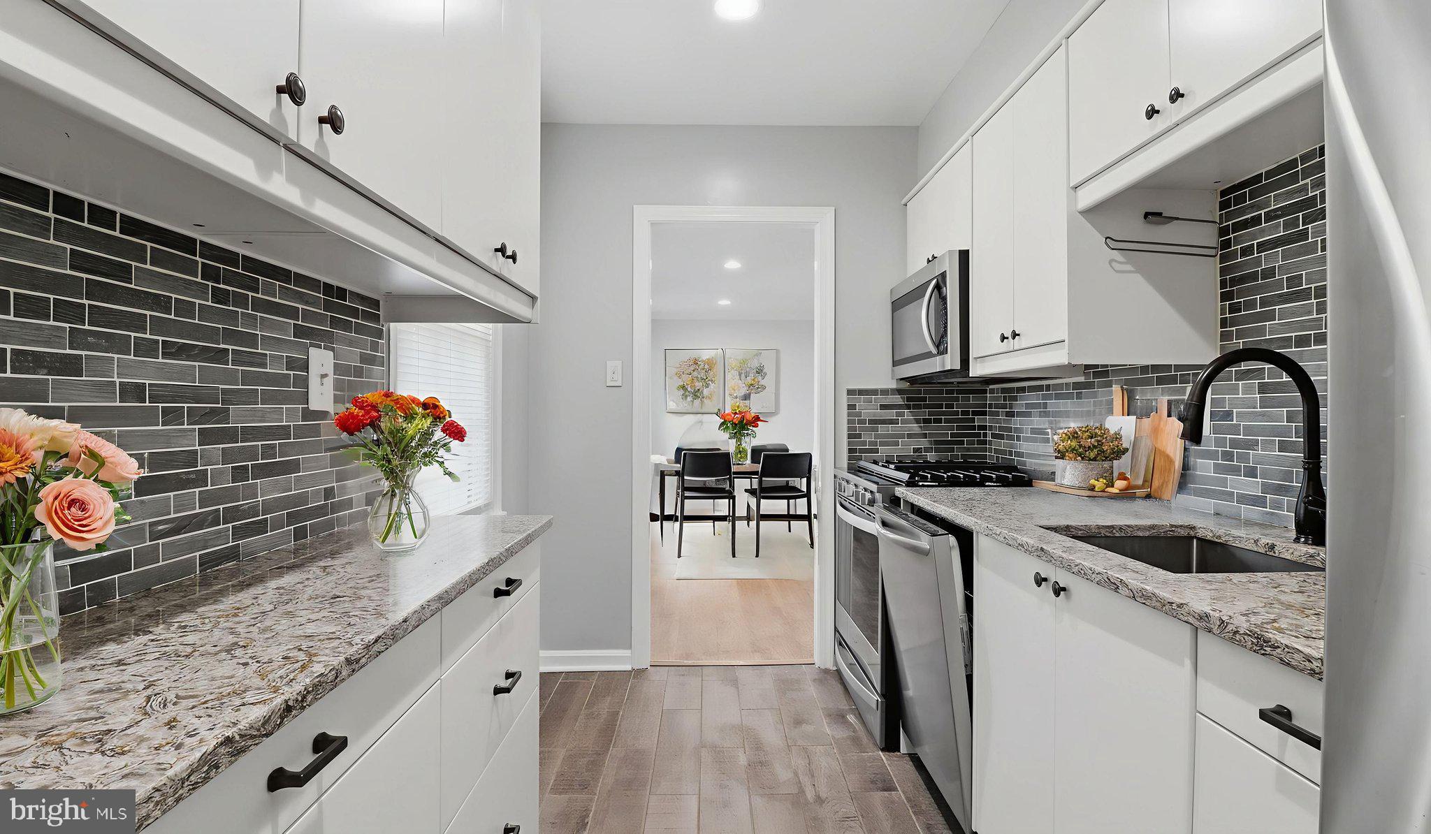 5100 Columbia Pike, Unit 1 Arlington, VA 22204 - Photo 32 of 40 a kitchen with granite countertop a stove a sink and a wooden cabinets