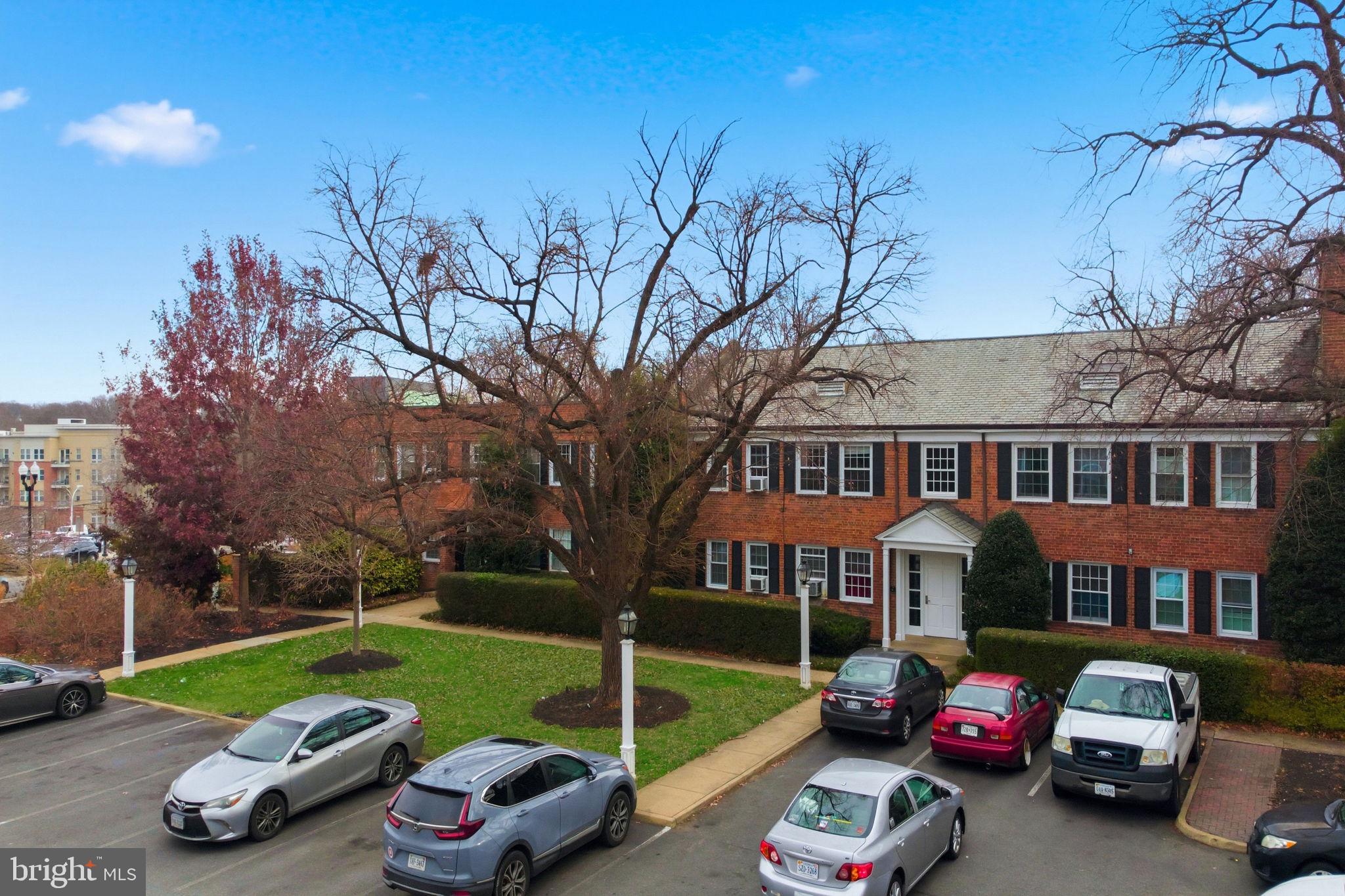 5100 Columbia Pike, Unit 1 Arlington, VA 22204 - Photo 35 of 40 a car parked in front of a brick house next to a yard