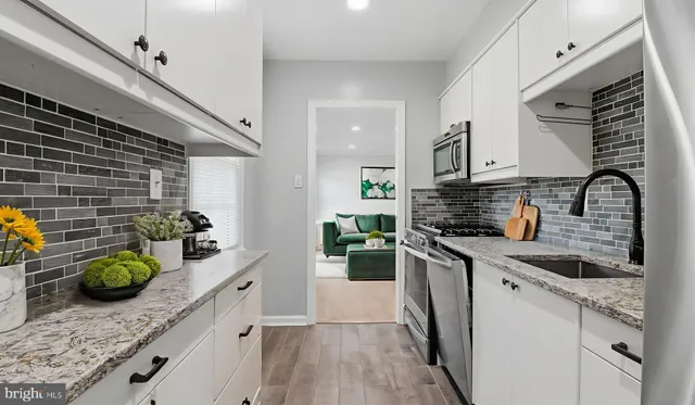 a kitchen with stainless steel appliances granite countertop a sink a stove and cabinets