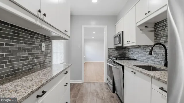 a kitchen with granite countertop a sink and a stove