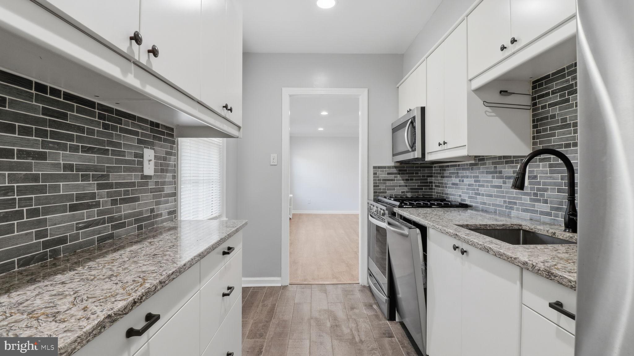 5100 Columbia Pike, Unit 1 Arlington, VA 22204 - Photo 10 of 40 a kitchen with granite countertop a sink and a stove