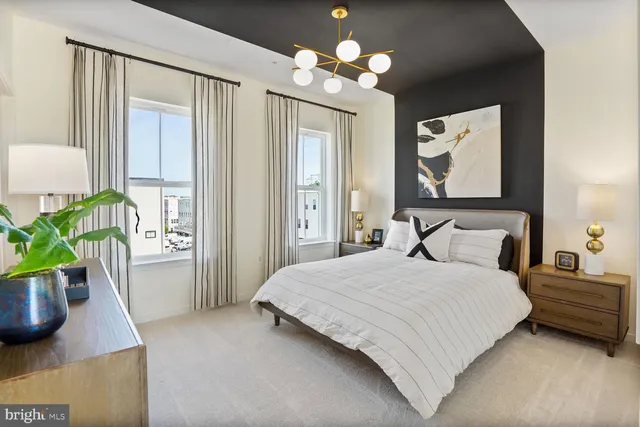 a bedroom with a bed potted plant on dresser and a window