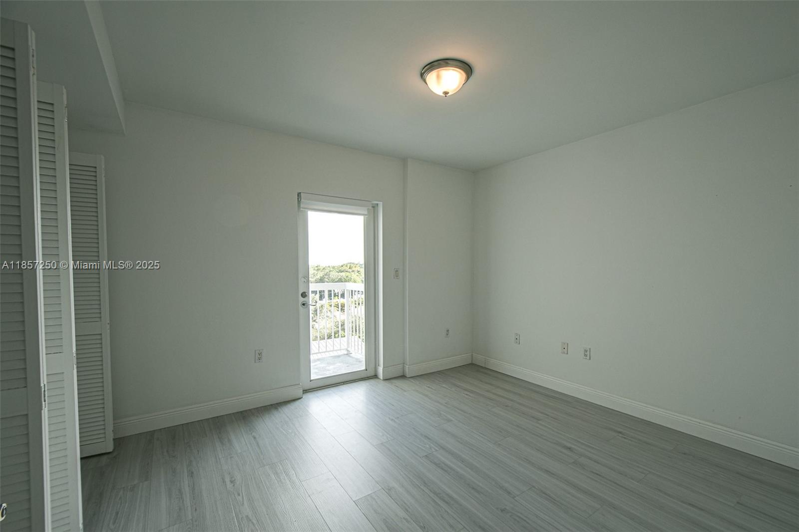 2740 Southwest 28th Terrace, Unit 603 Miami, FL 33133 - Photo 13 of 21 an empty room with wooden floor and windows