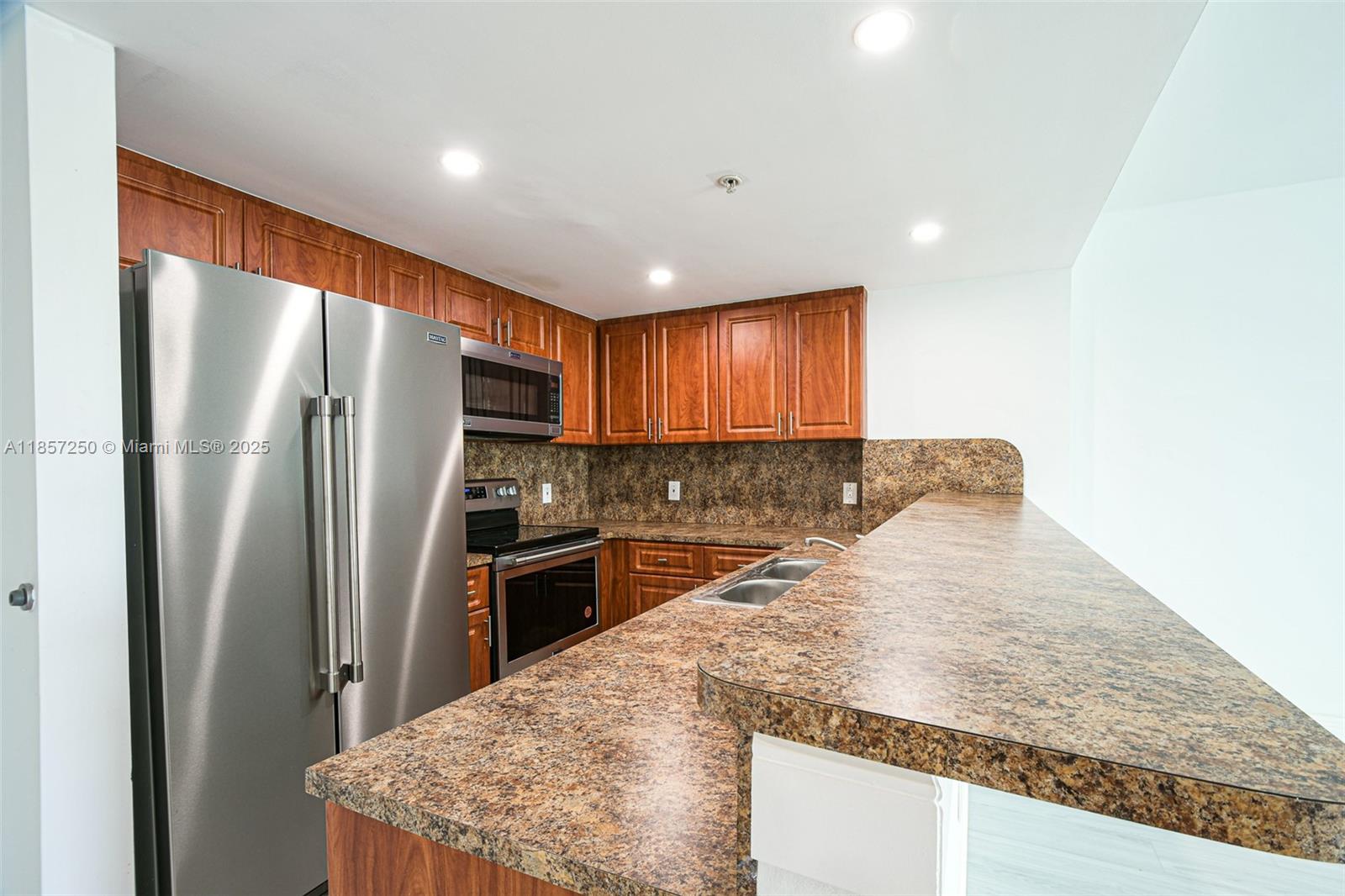 2740 Southwest 28th Terrace, Unit 603 Miami, FL 33133 - Photo 3 of 21 a kitchen with stainless steel appliances granite countertop refrigerator sink and stove