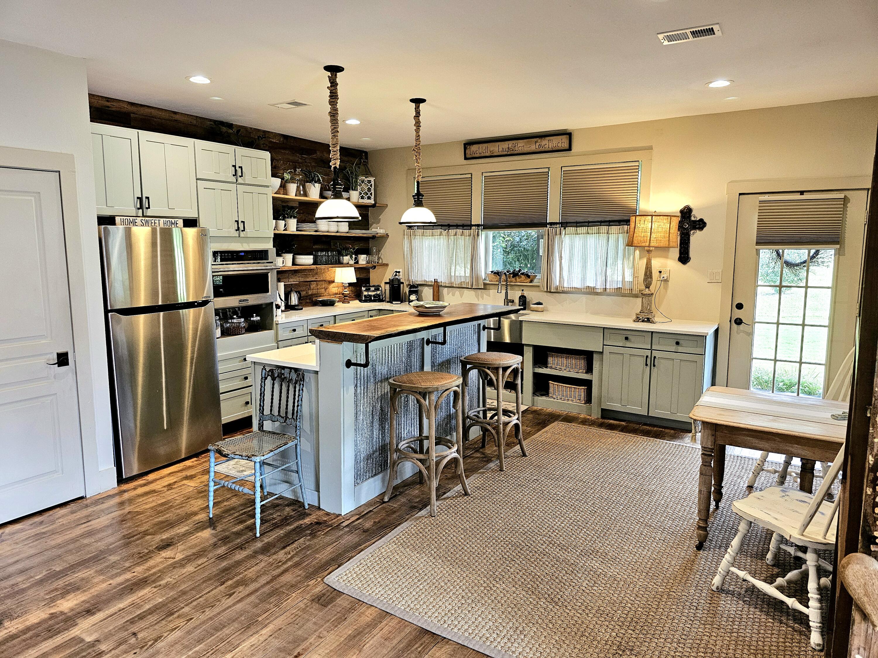 248 Blueberry Road Freeport, FL 32439 - Photo 7 of 37 a kitchen with stainless steel appliances granite countertop a table chairs refrigerator and microwave