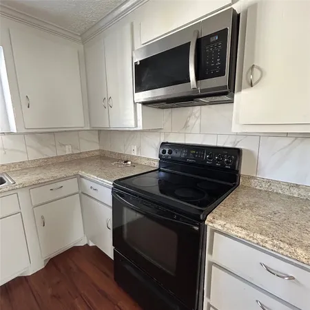a kitchen with granite countertop a stove and a microwave