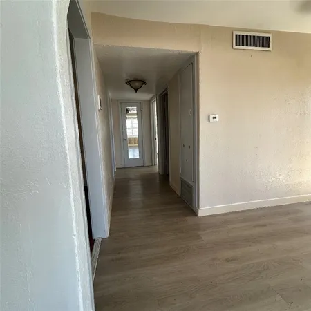 a view of a hallway with wooden floor and closet