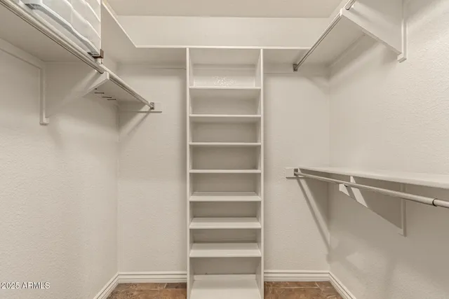 a view of walk in closet with empty racks