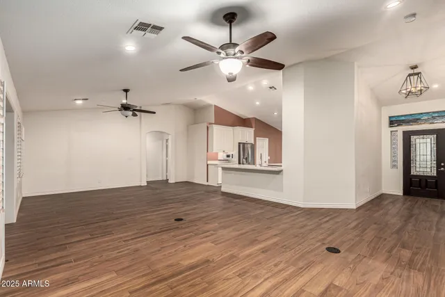 a view of a kitchen with a sink and chandelier stainless steel appliances
