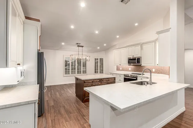 a large white kitchen with stainless steel appliances
