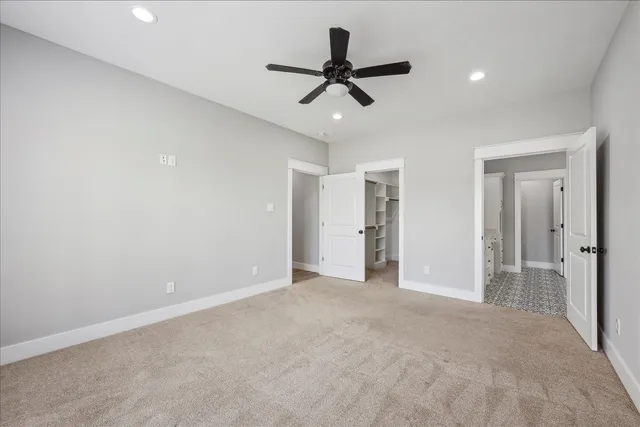 a view of a livingroom with a ceiling fan & entryway