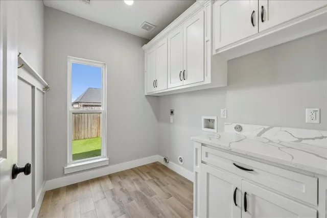 a kitchen with appliances cabinets and a wooden floor
