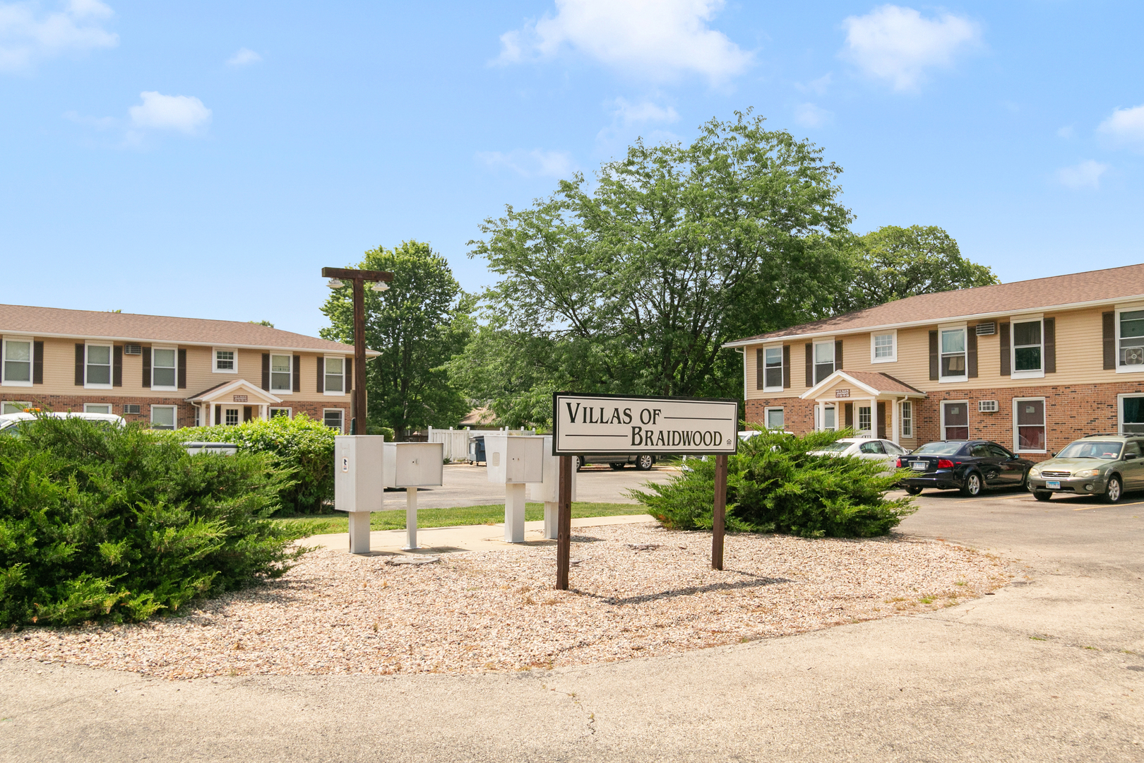 405 East Reed Street, Unit 9 Braidwood, IL 60408 - Photo 14 of 14 a white house that has a tree in front of it