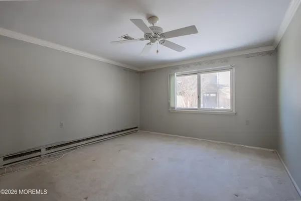 an empty room with a window and a ceiling fan