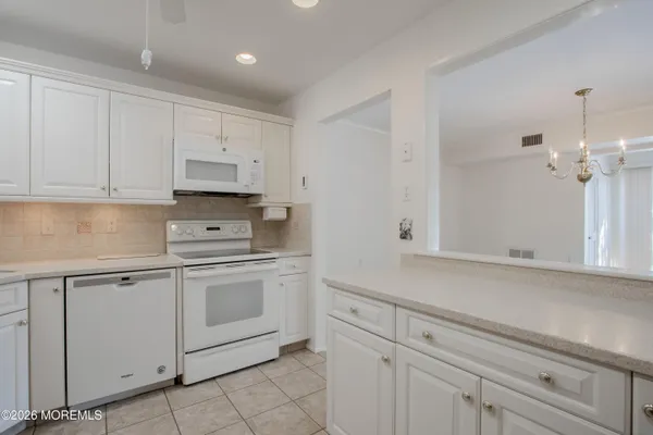 a kitchen with white cabinets and white appliances