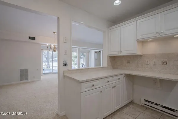a kitchen with white cabinets appliances a sink and a window
