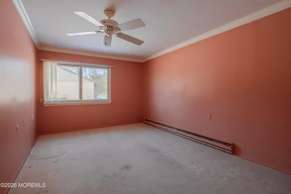 an empty room with windows and fan