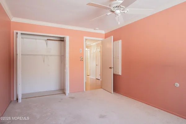 an empty room with closet and fan