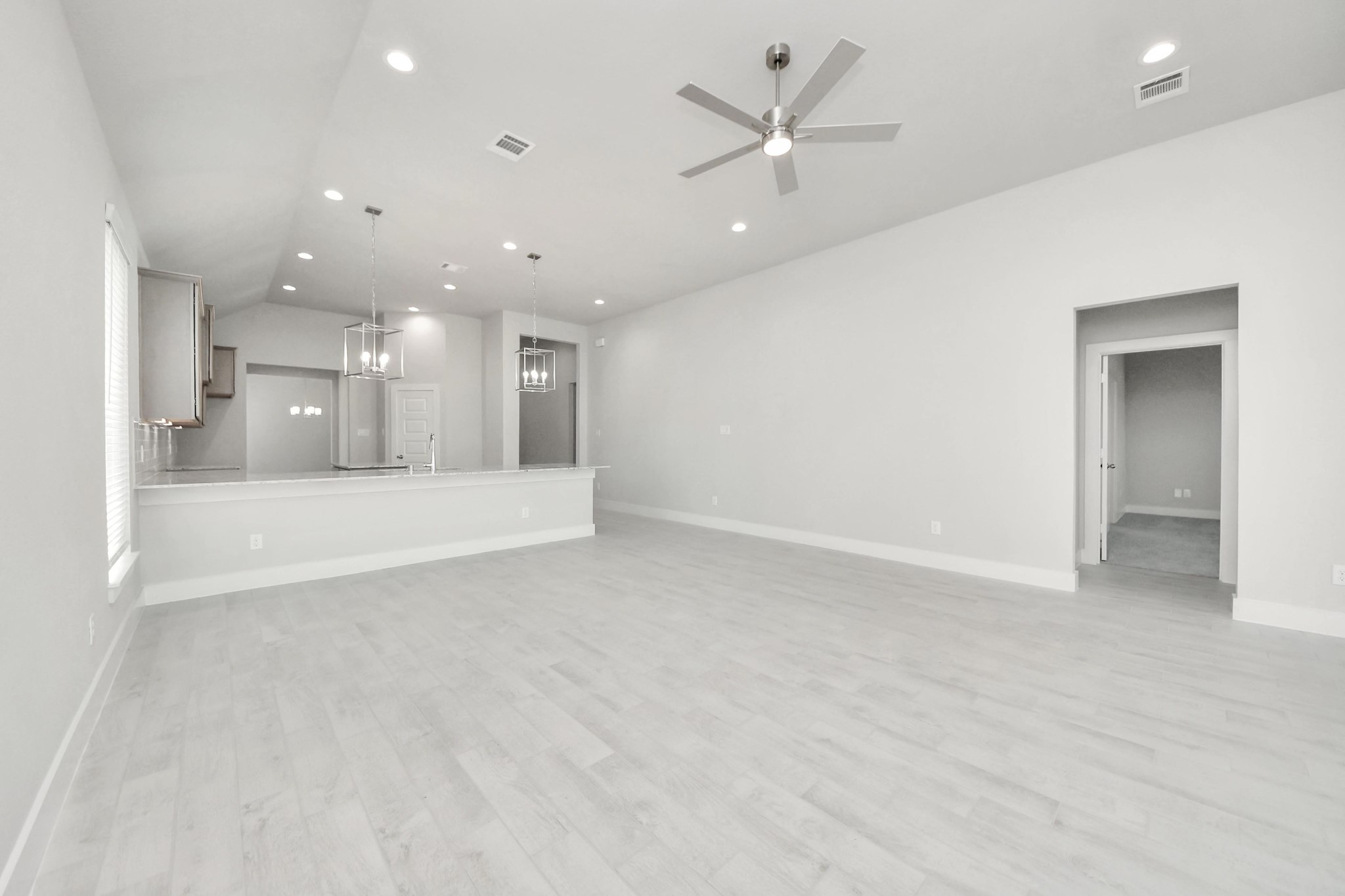 3042 Native Spg Drive Spring, TX 77373 - Photo 20 of 32 Relax and unwind in this inviting family room, illuminated by abundant natural light streaming in through tall windows, complemented by high ceilings and stunning flooring. Stay comfortable year-round with the gentle breeze from the ceiling fan, creating the perfect atmosphere for family gatherings. Sample photo of completed home with similar floor plan. Actual colors and selections may vary.