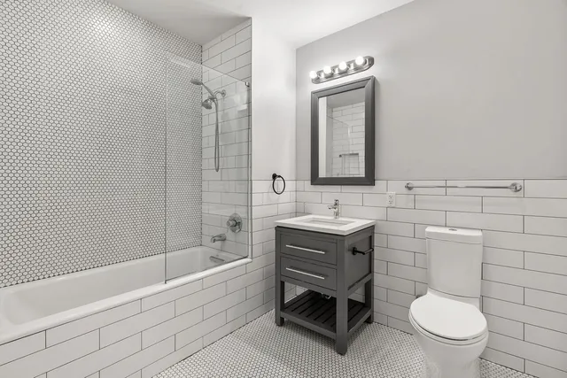 a bathroom with a toilet a sink a mirror and bathtub