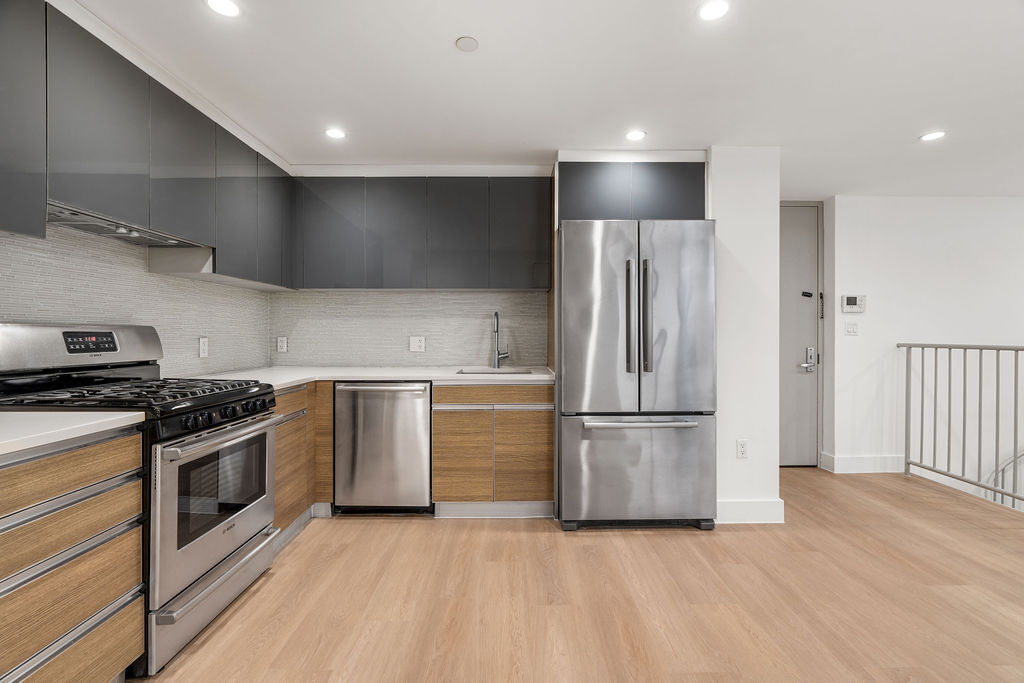 Undisclosed Address Queens, NY 11101 - Photo 3 of 21 a kitchen with stainless steel appliances granite countertop a refrigerator and a stove
