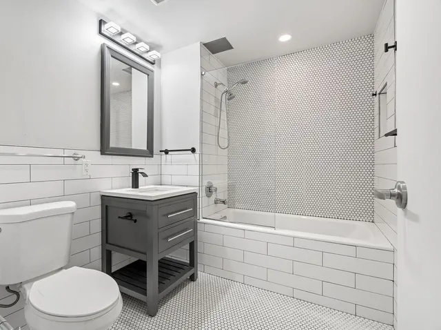 a bathroom with a sink a toilet and shower