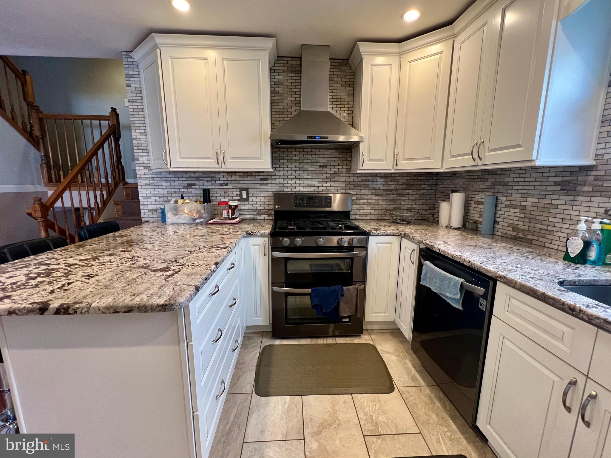 2988 Welsh Road Philadelphia, PA 19152 - Photo 13 of 38 a kitchen with granite countertop a stove top oven sink and cabinets