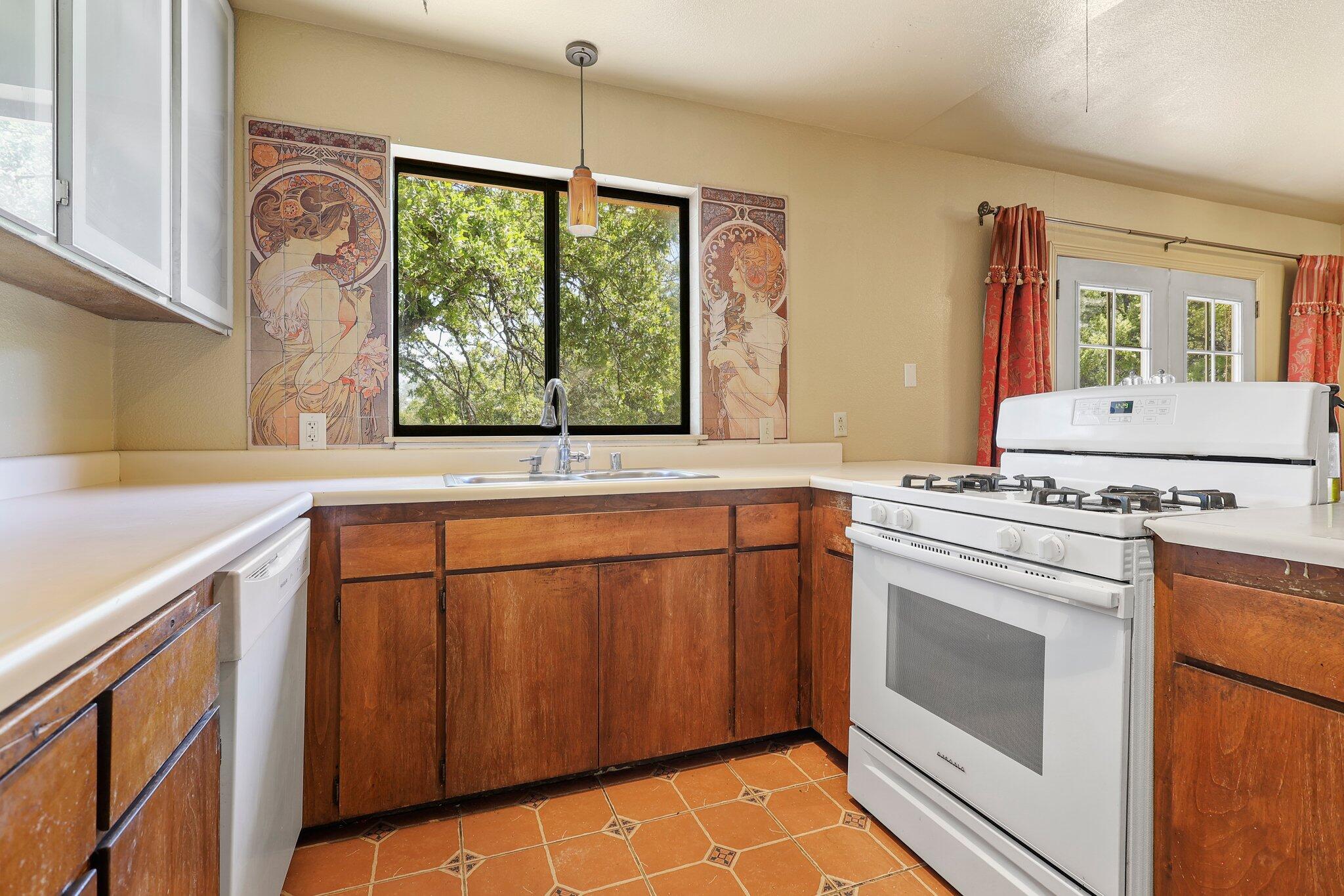 7741 Placer Road Redding, CA 96001 - Photo 13 of 24 a kitchen with stainless steel appliances granite countertop a stove a sink and a refrigerator