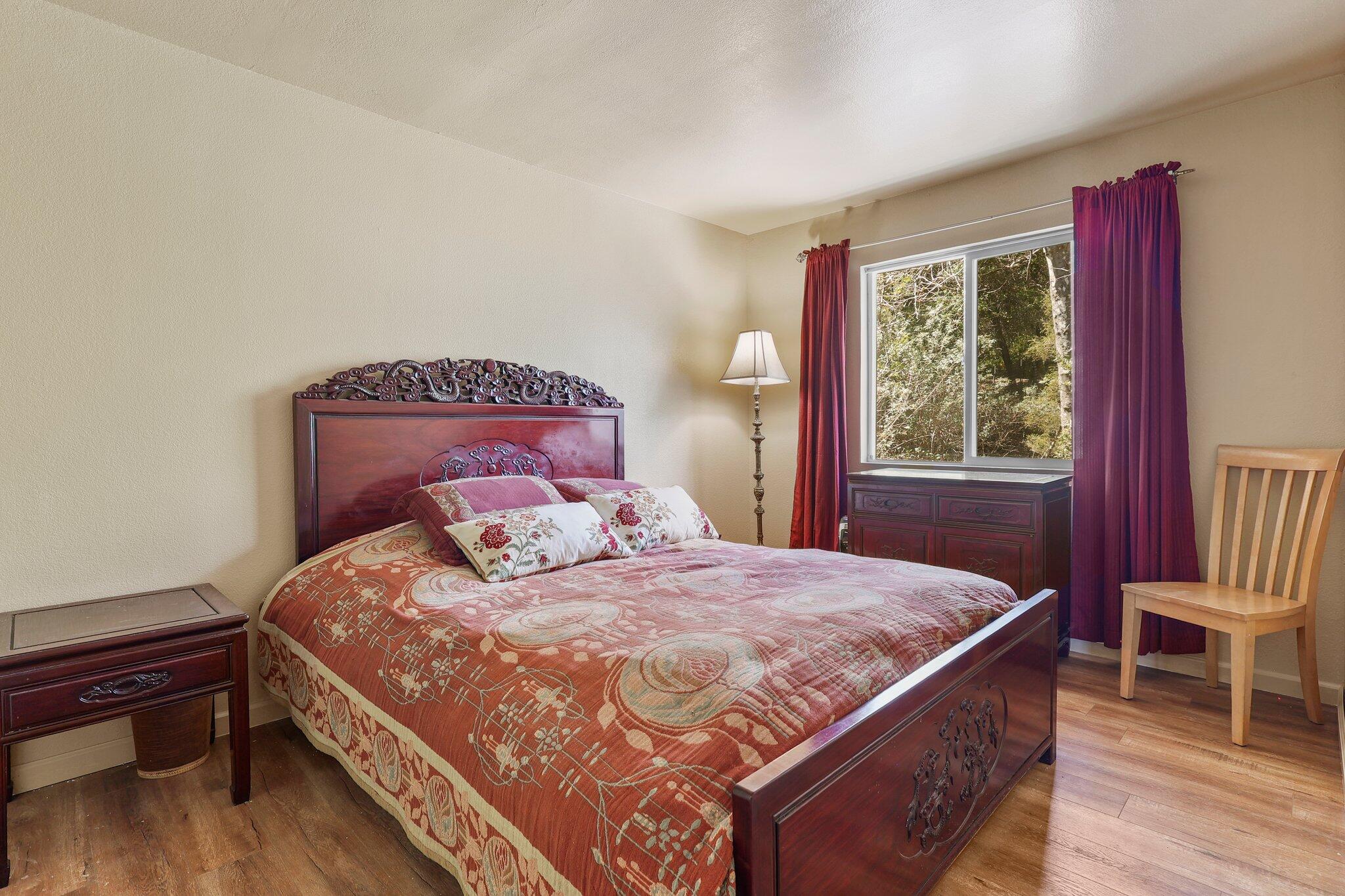 7741 Placer Road Redding, CA 96001 - Photo 16 of 24 a bedroom with a bed wooden floor and window