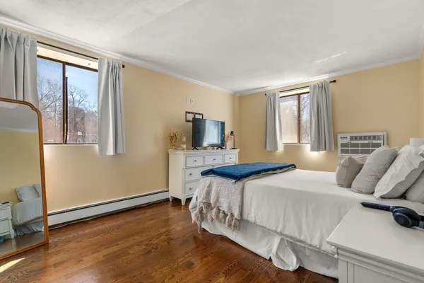 a bedroom with a bed and wooden floor