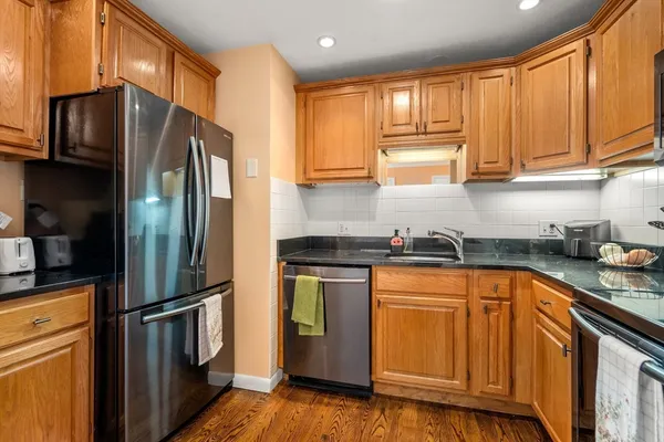 a kitchen with stainless steel appliances granite countertop a refrigerator stove and sink