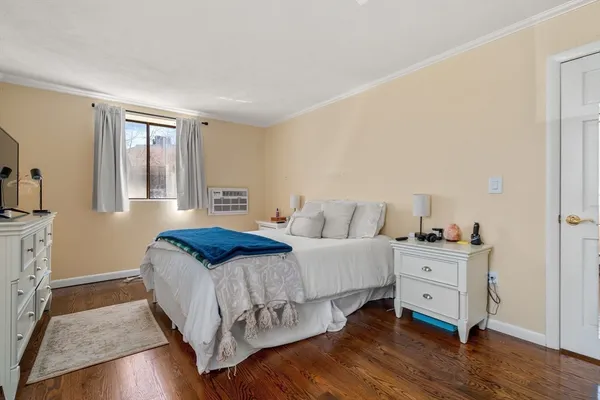 a bedroom with a bed and wooden floor