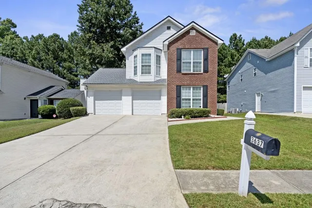 a front view of a house with a yard and garage