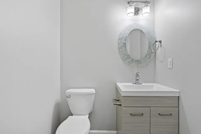 a bathroom with a toilet sink and mirror