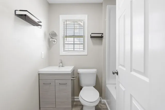 a bathroom with a toilet a sink and a window