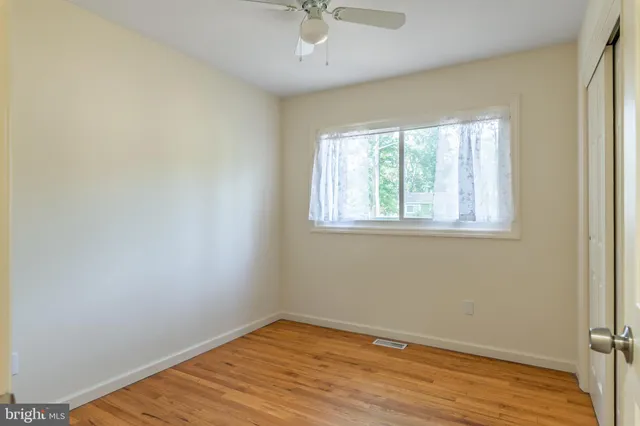 an empty room with a window and wooden floor